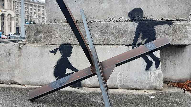 Street mural painted by Banksy in Independence Square, Kyiv. It depicts two children using a Czech hedgehog as a seesaw.